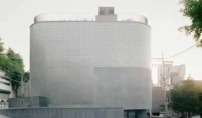 Wooyoungmi Seoul flagship exterior with curved glass block facade and textured concrete base
