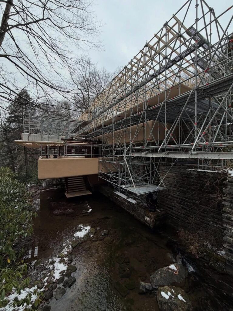 project showing scaffolding enveloping the cantilevered structure over Bear Run stream.