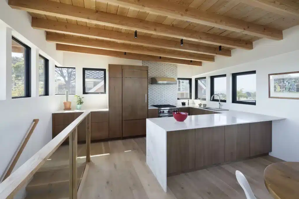 منظور خارجي لفيلا ساحلية حديثة مكونة من طابقين مع واجهات خشبية ونوافذ زجاجية كبيرة وإضاءة دافئة عند الغسق