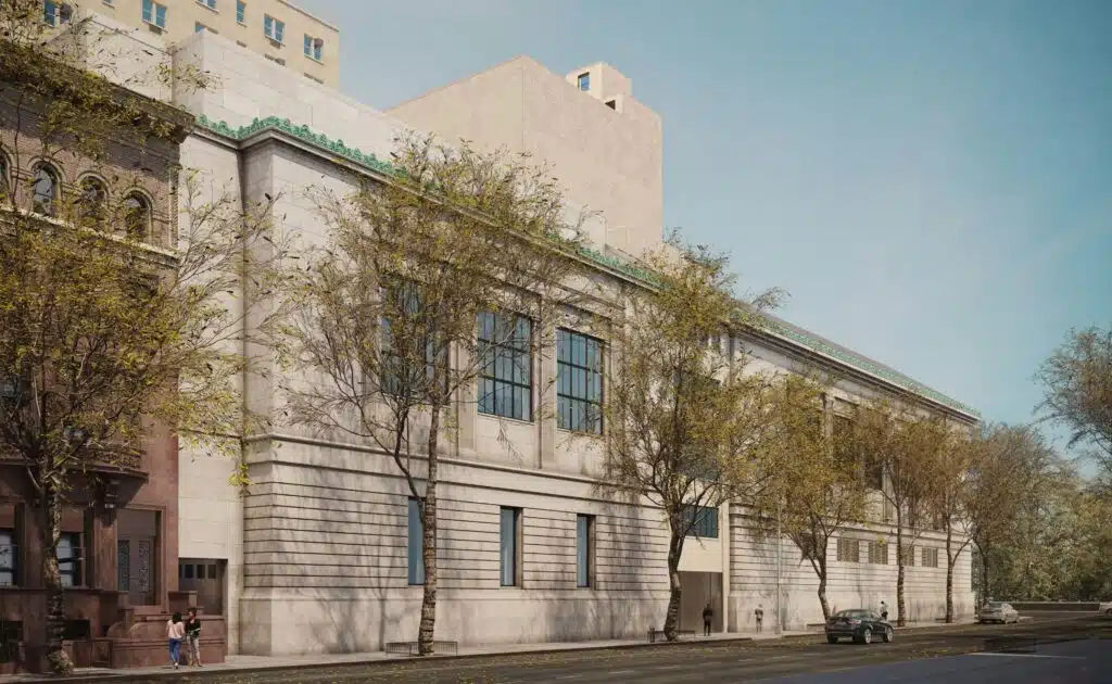 Limestone facade with green decorative trim, showcasing modern architectural design of the Tang Wing at the New-York Historical Society, framed by trees and pedestrians on the sidewalk.