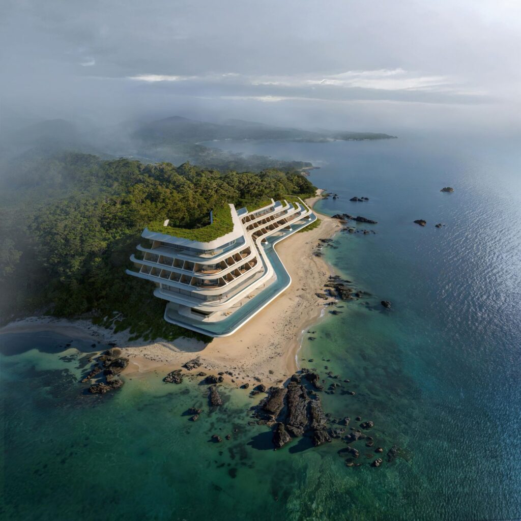 NOT A HOTEL Okinawa vertical hotel nestled on a forested coastal cliff, overlooking turquoise waters and distant islands under misty skies.