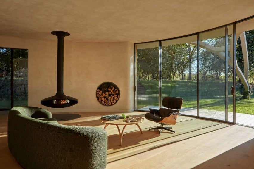 Living room with full glass views; interior timber flooring welcomes warm natural daylight.
