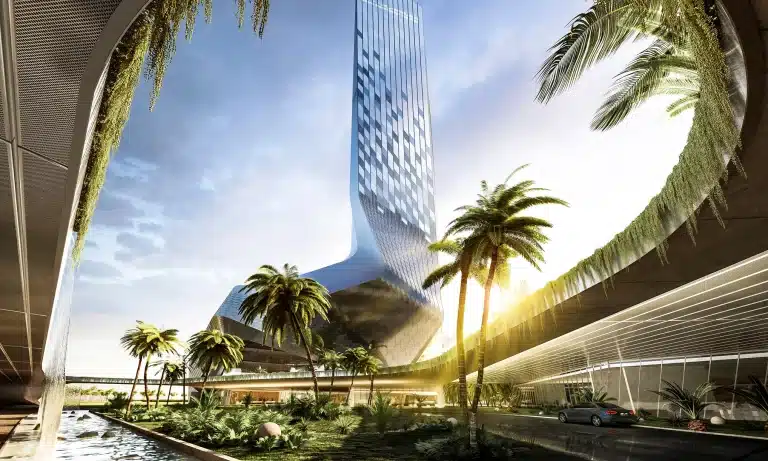 Main entrance framed by palm trees; golden light creates a sensory gradient between exterior and interior spaces.