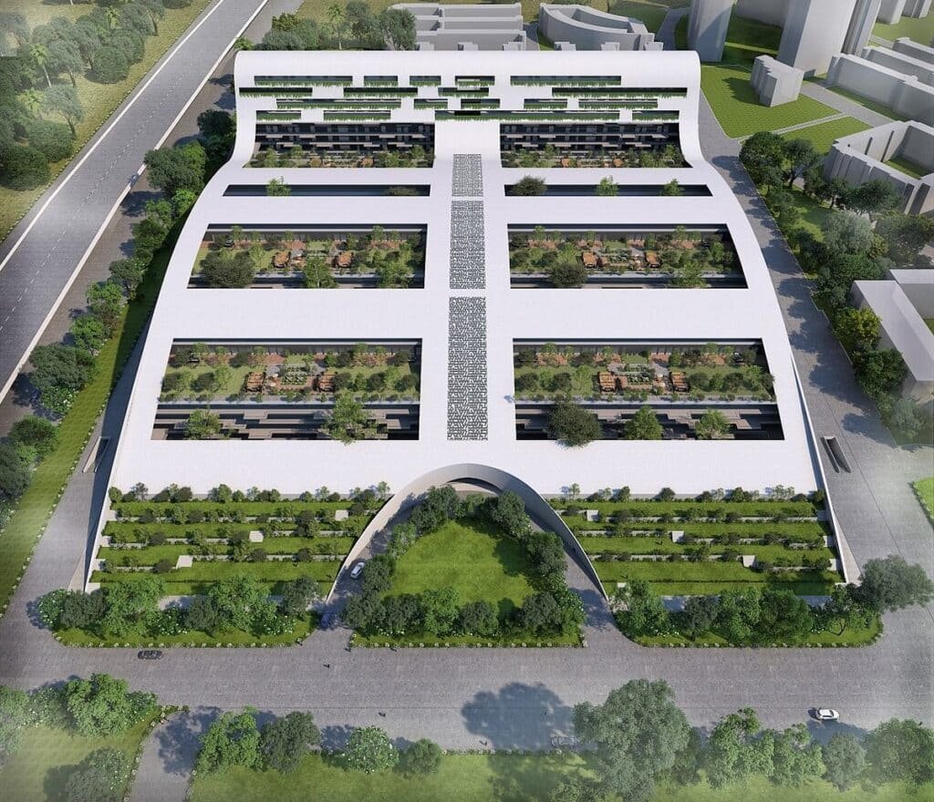 Aerial view of a white building with soft curves embracing open green interior gardens and the sky.