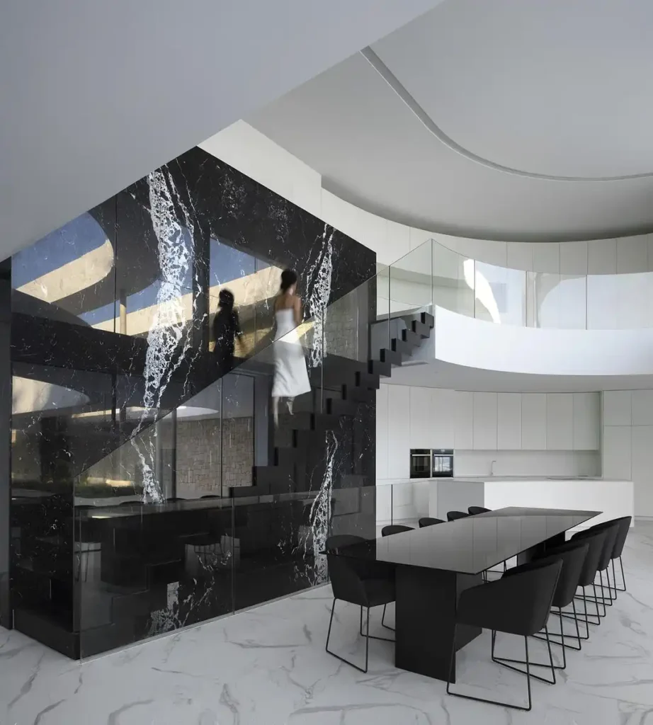 سلالم رخامية سوداء تلامس الضوء وتُضفي دراما معمارية في قلب المنزل