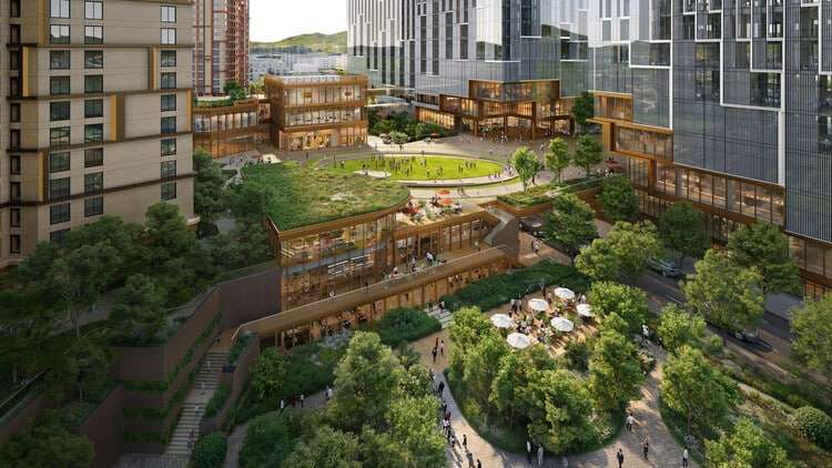Central green courtyard surrounded by wooden-roofed shops, interspersed with outdoor seating and pathways.