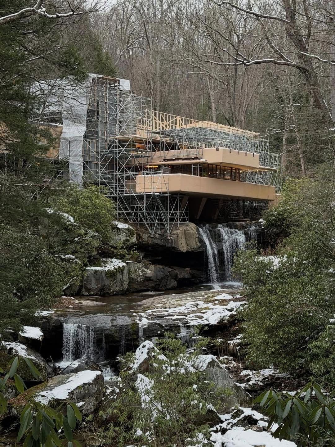 project with scaffolding enveloping the structure over a waterfall in winter.
