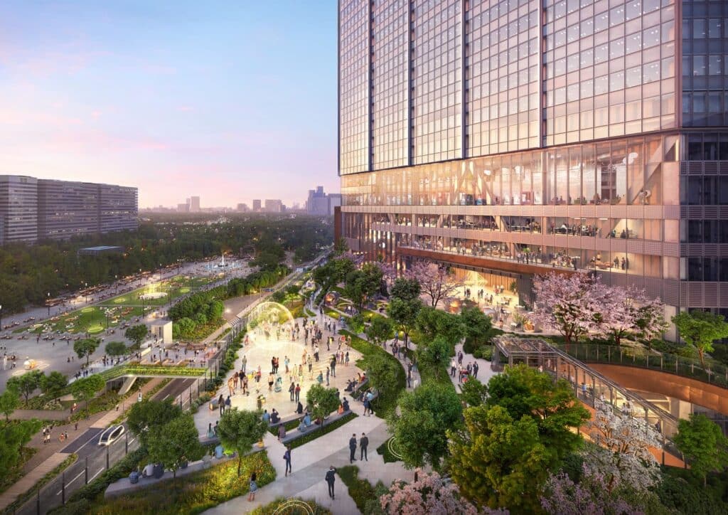 Aerial view of the Tokyo Cross Park public podium at dusk, showing a landscaped pedestrian zone with cherry blossoms and a glass-clad tower above, integrating urban green space with high-rise architecture.