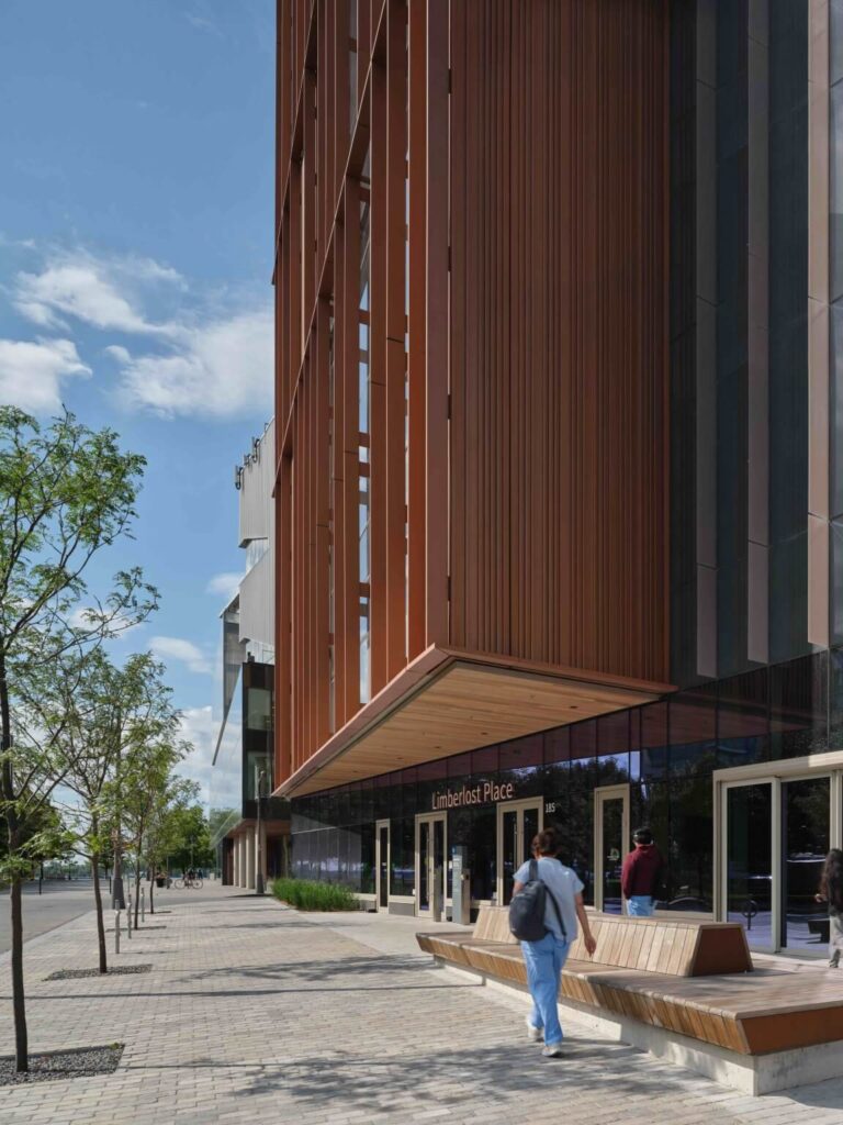 واجهة خشبية عمودية تُضفي دفئًا حضريًا تحت سماء زرقاء صافية