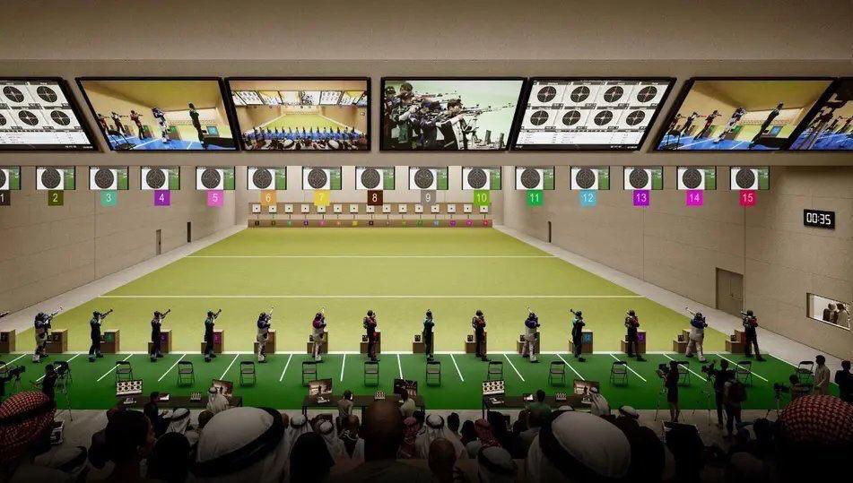 Modern indoor shooting range with tiered spectator seating and digital target displays, showcasing event infrastructure for precision sports in Saudi Arabia.