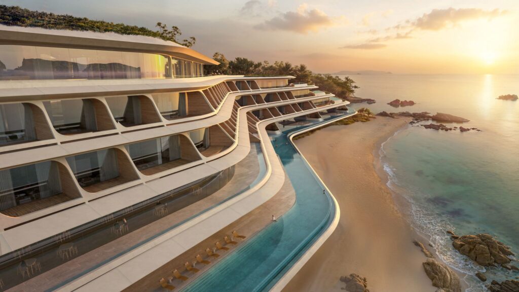 terraced structure with infinity pools cascading toward the beach, set against a sunset over the Pacific.