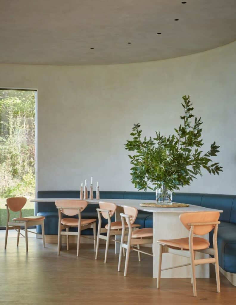 Curved dining area featuring deep blue leather banquette seating and subtle overhead lighting.