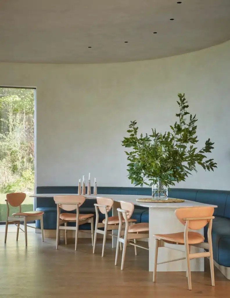 Curved dining area featuring deep blue leather banquette seating and subtle overhead lighting.
