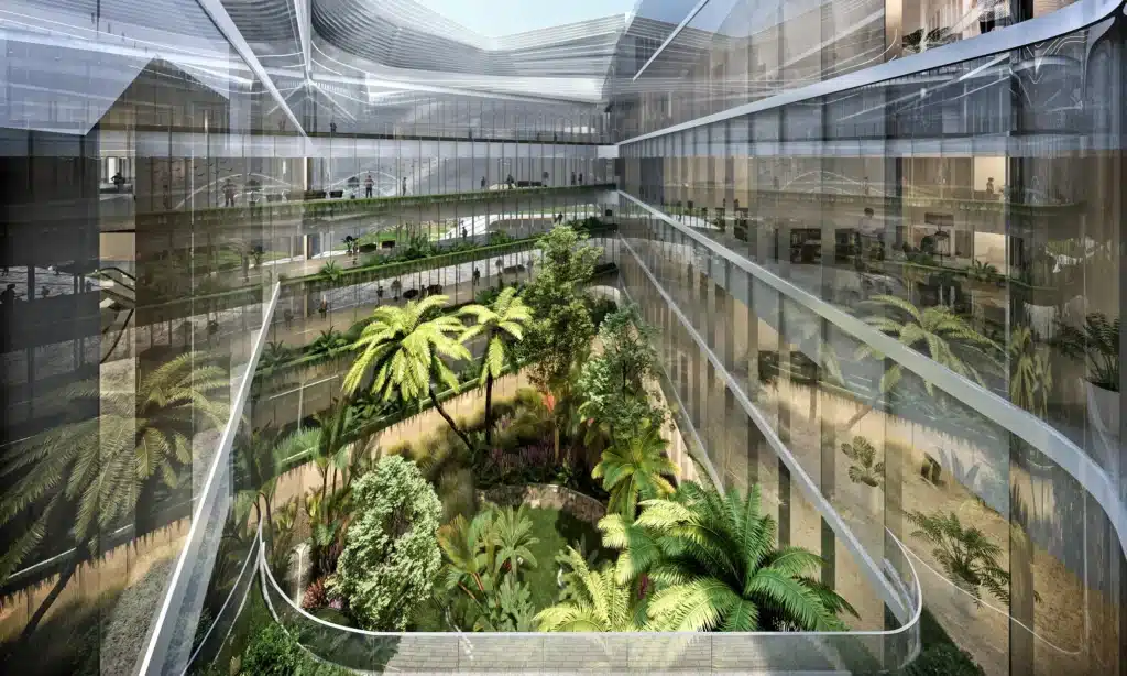 Massive glass-covered interior courtyard featuring tropical foliage, creating a calm, illuminated healing environment.