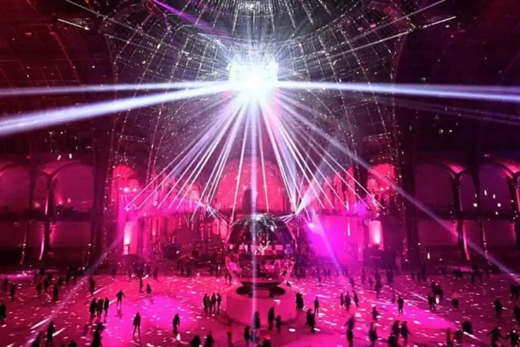 Night skating party: central disco ball releases pink laser beams across the architectural volume.