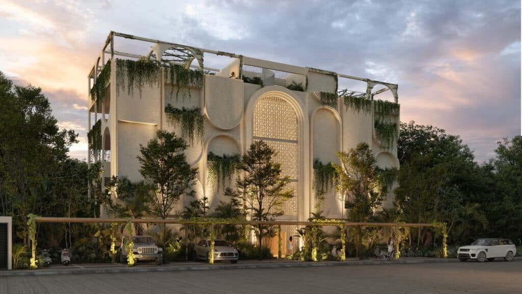 Vernal Tulum evening facade highlighting biophilic architecture with illuminated arches and vertical greenery.