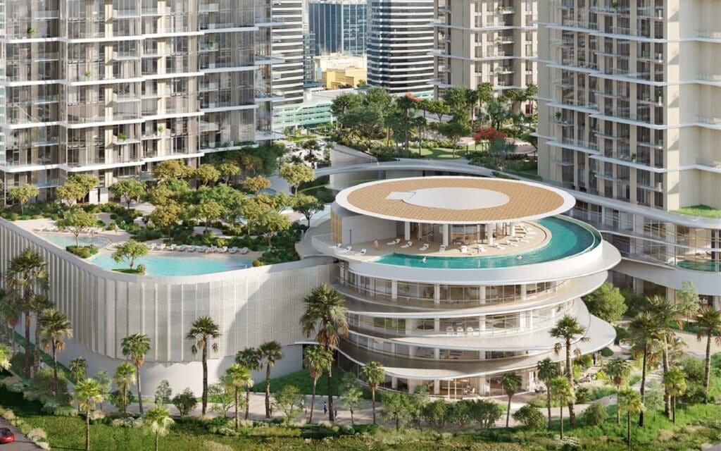 تصوير جوي لمبنى المرافق المركزي في منطقة سيرينيا بجزر جميرا، دبي، يضم سطحًا دائريًا للبرك محاطًا بأبراج شاهقة ومساحات خضراء كثيفة. ووضح تصاميم المعماريه