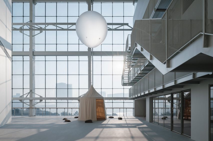 Espace Gabrielle Chanel exhibition space with suspended white sphere, fabric tent, and industrial steel staircase within Shanghai&rsquo;s Power Station of Art.