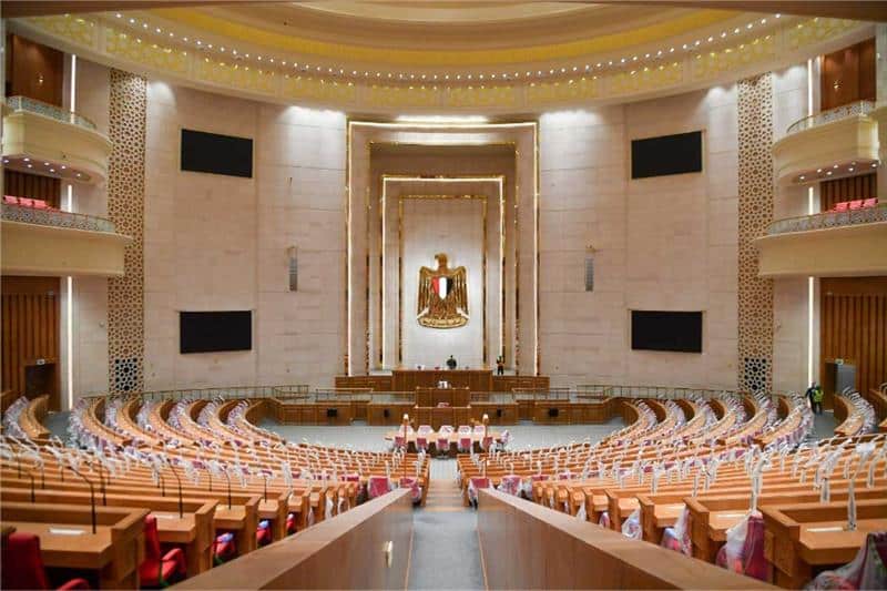 Parliamentary architecture interior: tiered seating, central podium, and golden emblem define the legislative space in Egypt&rsquo;s new parliament.