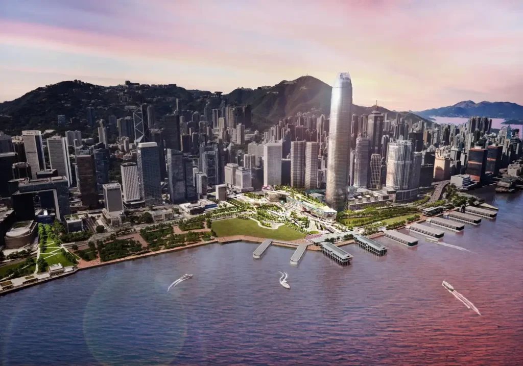Aerial rendering of the Central Yards development on the Hong Kong waterfront, showing the theatre complex, green spaces, piers, and surrounding cityscape at sunset.