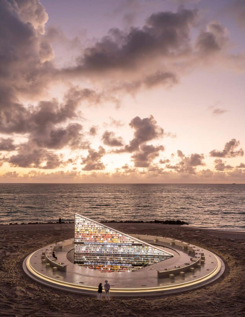 التكوين المثلث يضيء عند الغسق، مُحدِثاً تفاعلاً عاطفياً بين الهندسة والبحر والسماء.