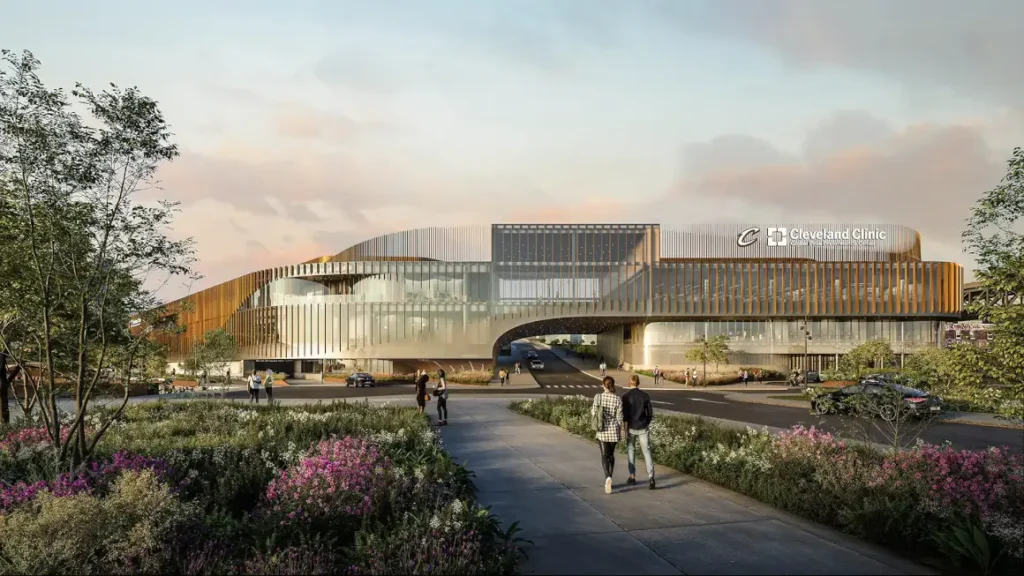 زاوية المشاة تُظهر تداخل المبنى مع مسارات السيارات، وسط الحدائق المنسقة ذات الإضاءة الطبيعية.