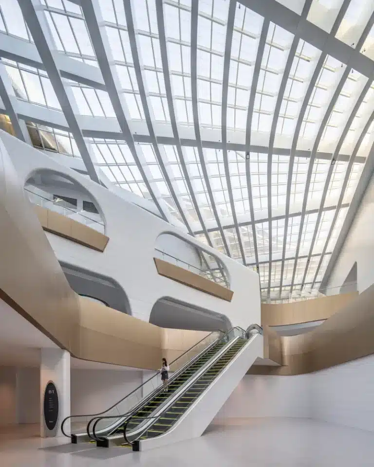 Luminous atrium allows daylight to flood the curved glass ceiling, guiding visitor movement and flow.