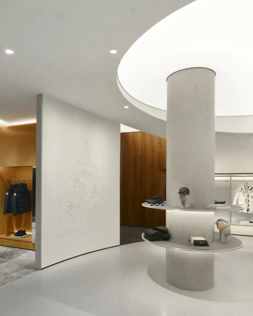 The curved white wall separates the display area from the warm wood section in a gradual transition.