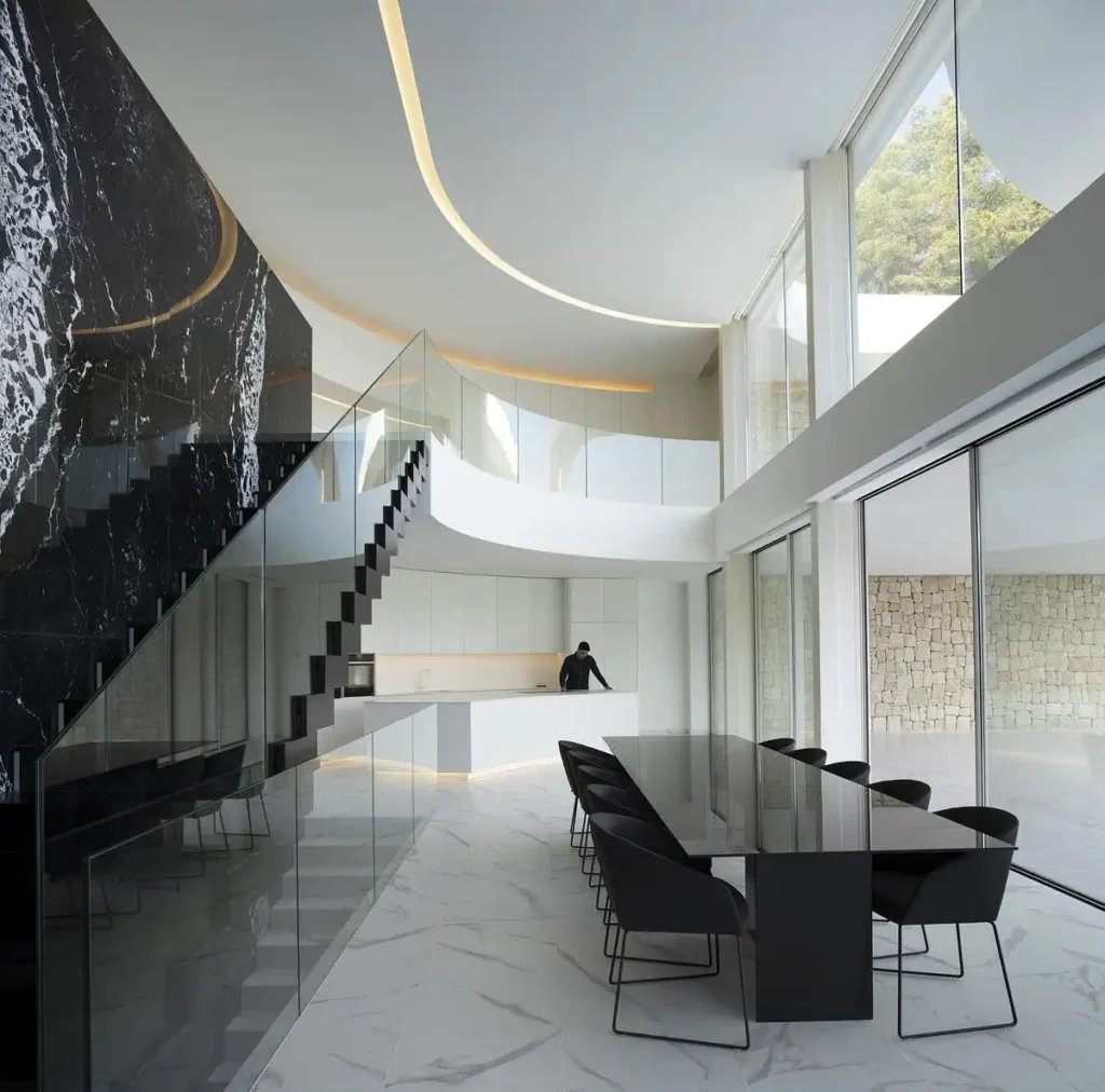 رخام أسود وأبيض يلتقيان في سلالم زجاجية تُضيء بضوء مخفي من السقف