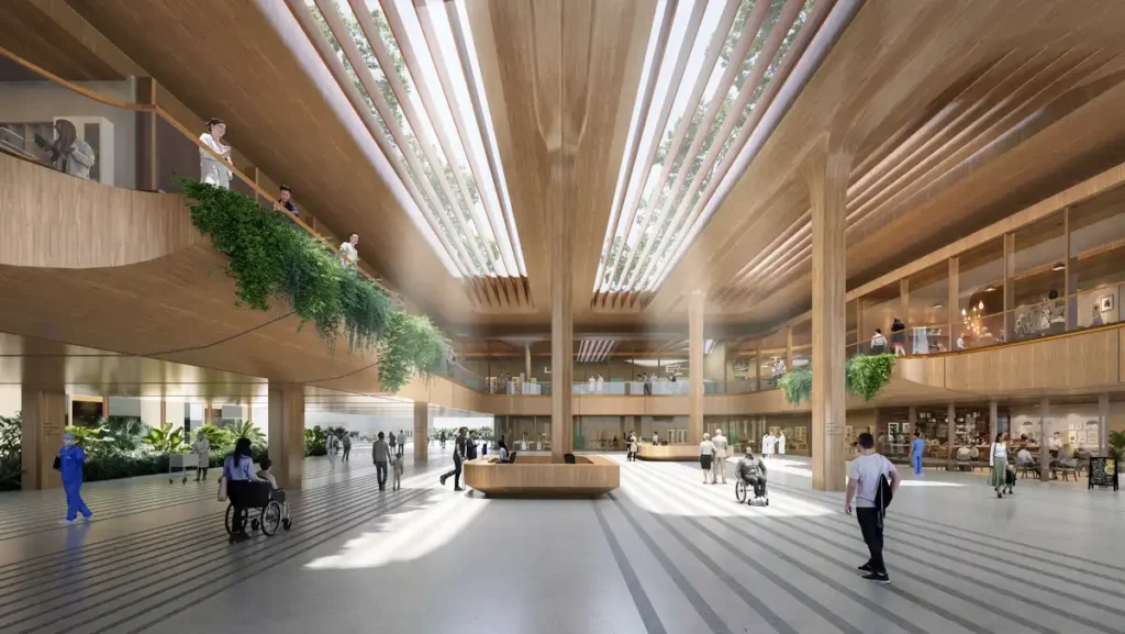 Interior lobby of Malpensa Hospital by Zaha Hadid, showing a flowing wooden ceiling with natural light and integrated greenery to support patient centered design.