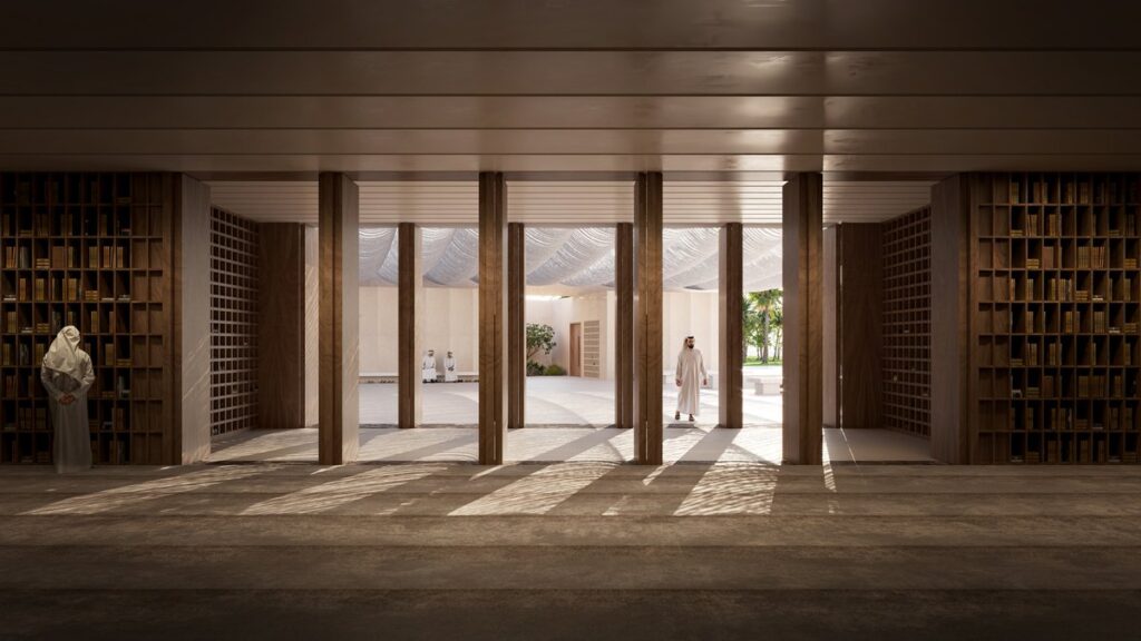 Interior view of the Mosque showing a colonnaded corridor with wooden bookshelves, concrete floors, and natural light filtering through the canopy above.