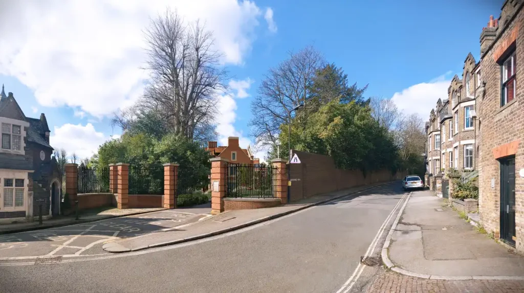 صورة مدخل الشارع لموقع برانش هيل، تظهر البوابات الحديدية وجدران الطوب المحيطة بالموقع قبل ترميم المباني التاريخية.