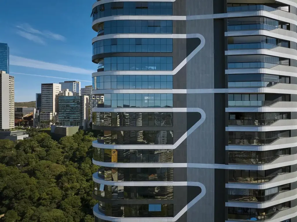 Close-up aerial view of Edif&iacute;cio Mir&oacute; Tower&rsquo;s facade, highlighting its wavy white bands against dark glass panels and reflecting the surrounding urban skyline.