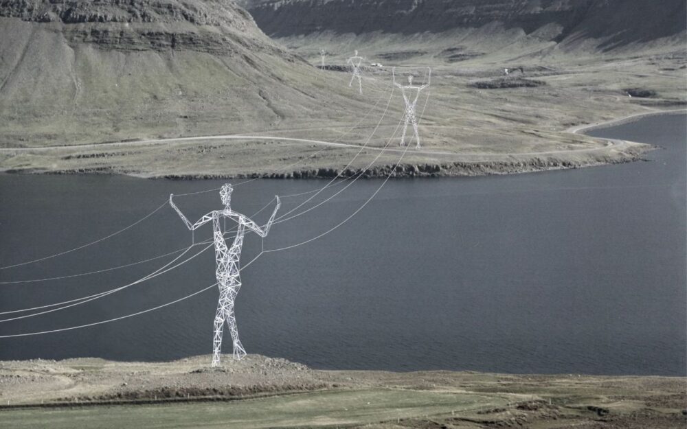 برج نقل كهرباء مفاهيمي على شكل إنسان، يقف بجانب بحيرة في مشهد صخري، يدمج الشكل مع الوظيفة.