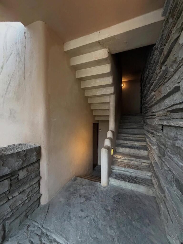 Interior concrete and stone staircase at   showcasing materials under structural review.