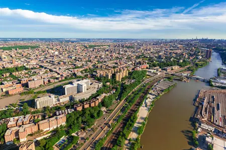 Aerial view of the Bronx, New York, showcasing Westchester Creek and the newly completed Unionport Bridge — a critical node in the urban infrastructure network connecting residential, commercial, and maritime corridors.