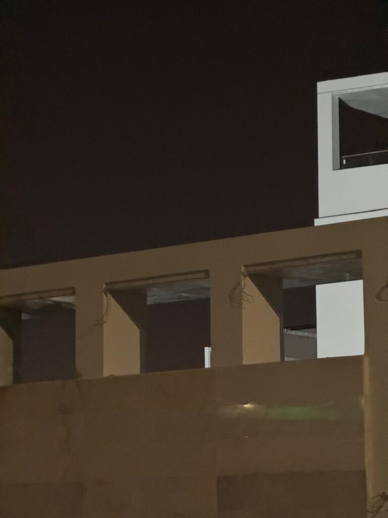 Minimalist concrete building facade under a dark night sky reflecting architectural isolation and geometric voids.