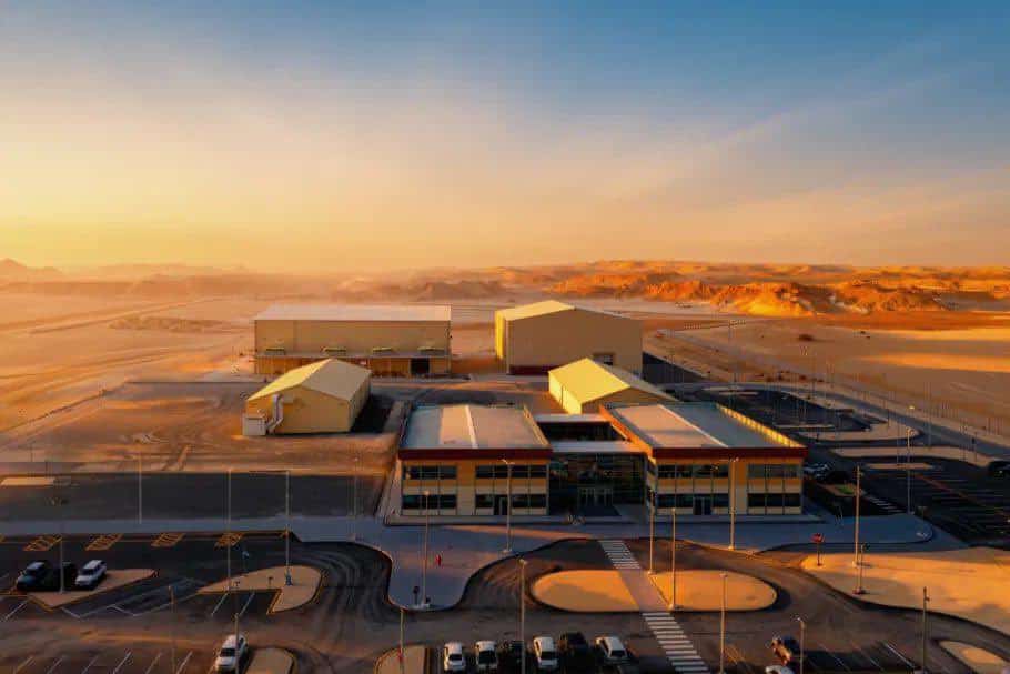 Production studio buildings during the day, showing industrial materials in a bright, sunny desert environment.