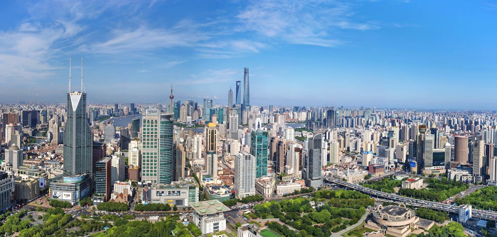 A stunning aerial view of Shanghai's modern skyline with iconic skyscrapers under a clear blue sky.