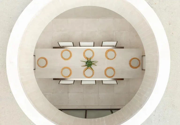 Direct overhead shot of the circular oculus highlighting the central dining area in the Backyard Sanctuary.