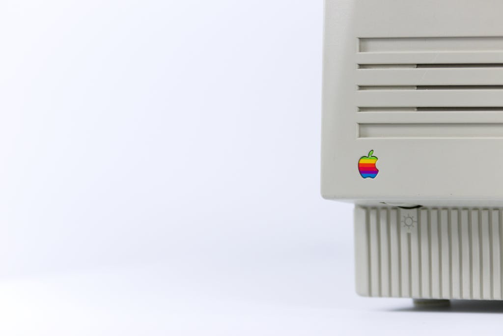 Close-up of a vintage computer monitor featuring a colorful logo on a minimalist background.