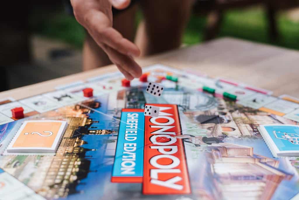 Close-up of Monopoly Sheffield Edition with dice mid-air on board.