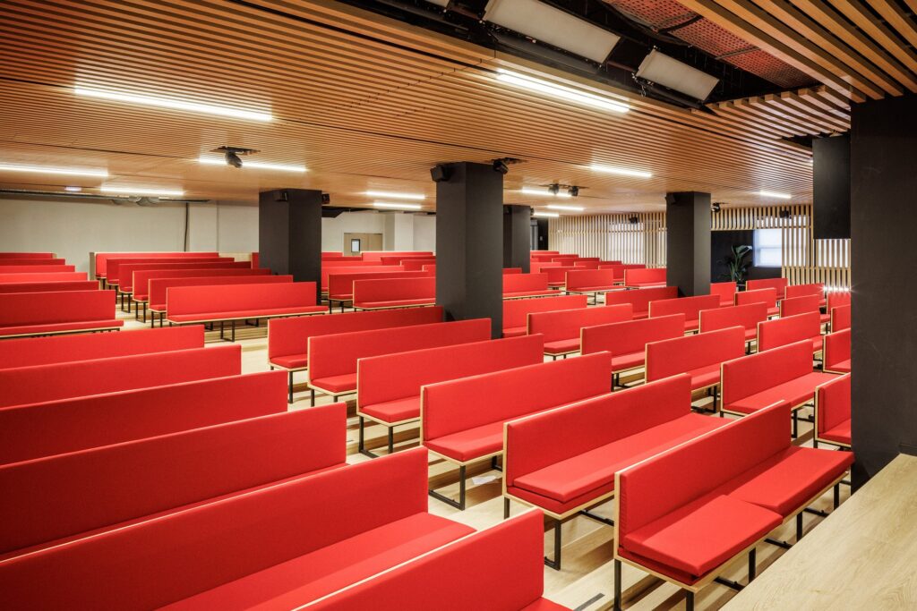 42UP vertical campus in Paris showcasing innovative architectural solutions including suspended bridge structures, perforated metal facades, open-plan educational floors, integrated urban ecosystem with NOC42, and vertical art installations enhancing student experience.