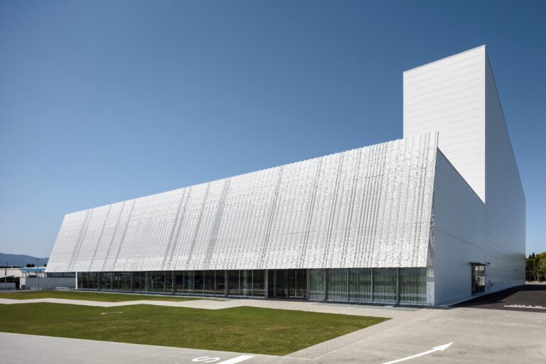 Hair care products factory in Kosatsu, integrating industrial design with natural environment and surrounding water for sustainability.