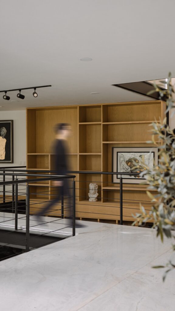 Casa EV residential design in Guadalajara featuring innovative integration of privacy, natural light, wooden materials, interconnected living spaces, central staircase, and landscaped exterior blending indoor and outdoor experiences.