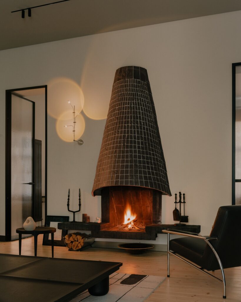 Private residence interior reflecting the owner's personality with natural materials, neutral colors, flexible spaces, and central fireplace, balancing functionality and aesthetics.