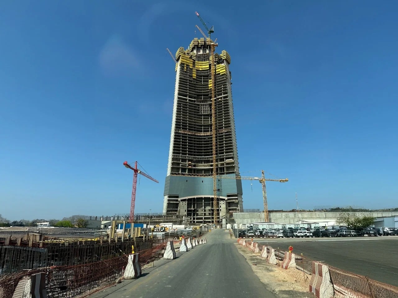 JEC Tower in Jeddah under construction, showcasing its central core, mixed-use spaces including offices, hotel, residential units, and engineering challenges as it rises above 1 kilometer, providing insight into modern skyscraper design and construction techniques
