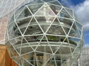 A high-tech vertical hydroponic system inside a climate-controlled dome showing stacked crops, LED lighting, and sustainable urban food production.