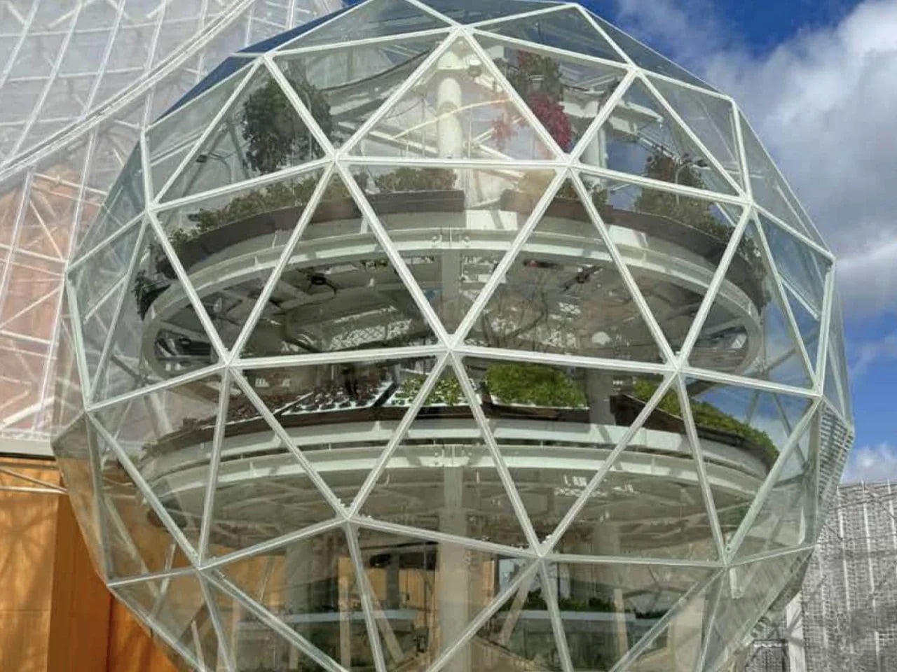 A high-tech vertical hydroponic system inside a climate-controlled dome showing stacked crops, LED lighting, and sustainable urban food production.