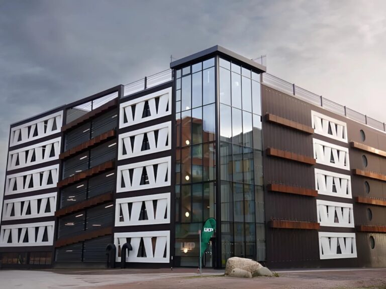 Exterior view of Niels Bohr parking garage in Lund featuring a facade made from repurposed wind turbine blades and a glass corner tower.